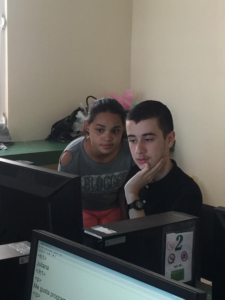 Foto de Ambar Alvarez, apoyando a un niño participante de uno de los talleres de programación.