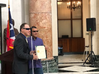 Foto de José Manolo Alvarez recibiendo el certificado con el reconocimiento del Día del Bastón Blanco de parte del Representante Néstor Alonso.