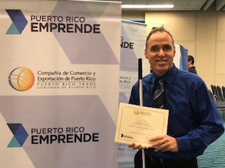 Foto de José Manolo Alvarez mostrando el certificado como ganador del primer lugar de la competencia de videojuegos.