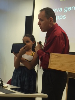 Foto de Manolo junto con su hija Ambar, demostrando varias apps y softwares durante la charla.