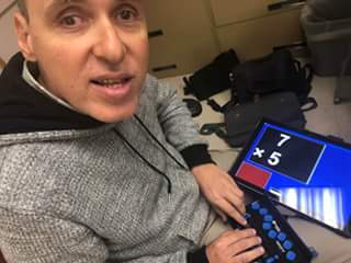 Foto de Manolo demostrando una línea braille conectada a una tableta con una fórmula matemática.